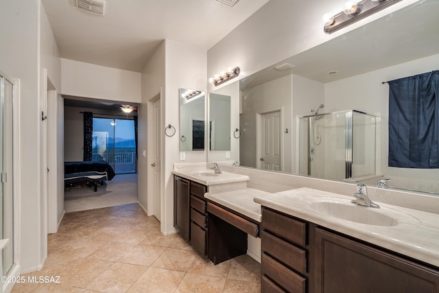 ensuite bathroom featuring connected bathroom, a sink, visible vents, double vanity, and a stall shower