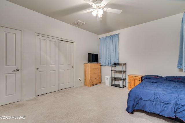 bedroom featuring a closet, visible vents, a ceiling fan, and light colored carpet