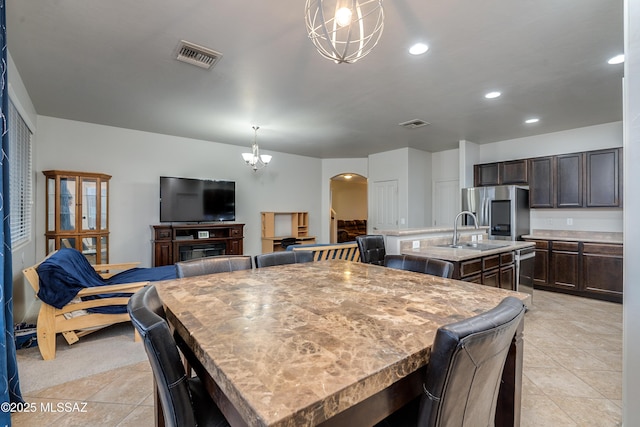 dining space with light tile patterned floors, arched walkways, visible vents, and recessed lighting