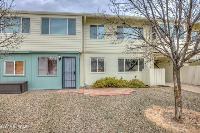 view of front of property with brick siding and fence