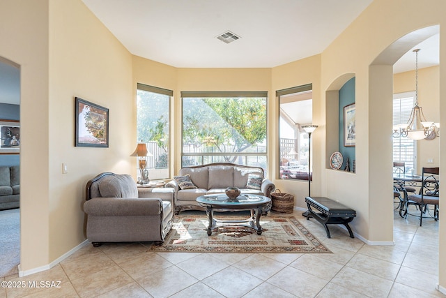 living area with a chandelier, visible vents, baseboards, and light tile patterned floors