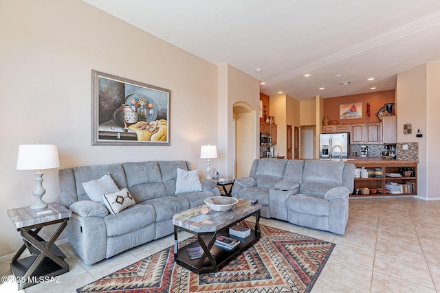 living room featuring recessed lighting, arched walkways, and light tile patterned floors