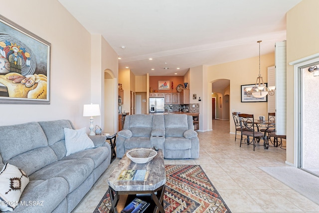 living room featuring arched walkways, recessed lighting, an inviting chandelier, light tile patterned flooring, and baseboards