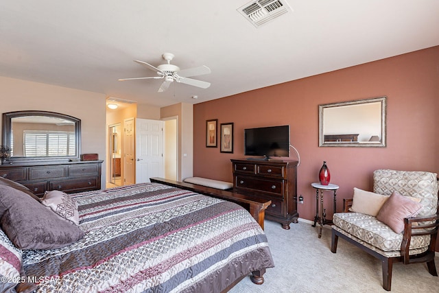 bedroom featuring ensuite bathroom, a ceiling fan, visible vents, and light colored carpet