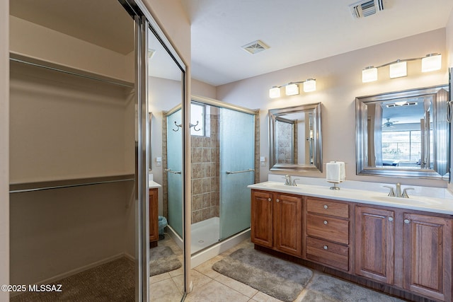 full bathroom featuring double vanity, a sink, visible vents, and a shower stall