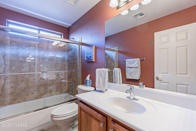 bathroom with toilet, vanity, visible vents, and enclosed tub / shower combo