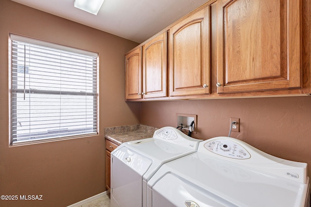 clothes washing area featuring cabinet space, baseboards, and separate washer and dryer