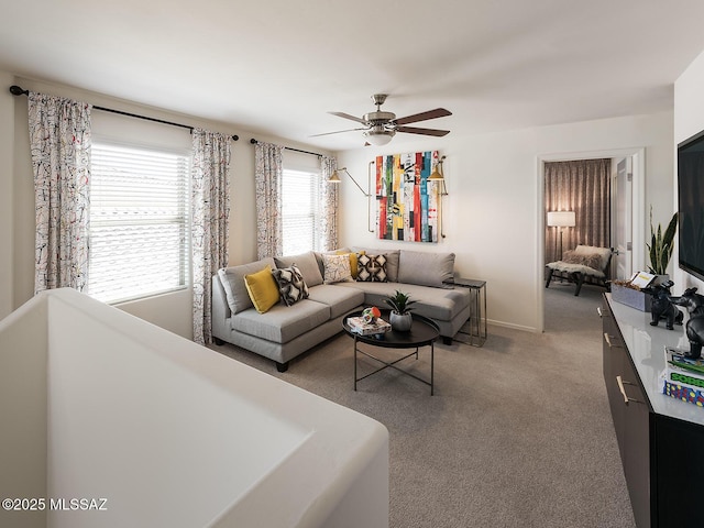 carpeted living room featuring a ceiling fan and baseboards