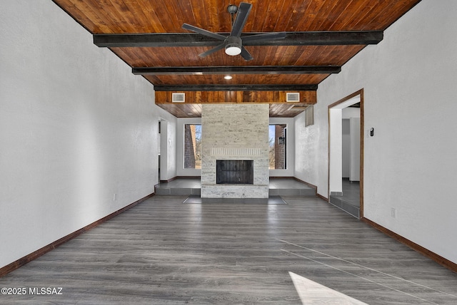 unfurnished living room with a large fireplace, wooden ceiling, and baseboards