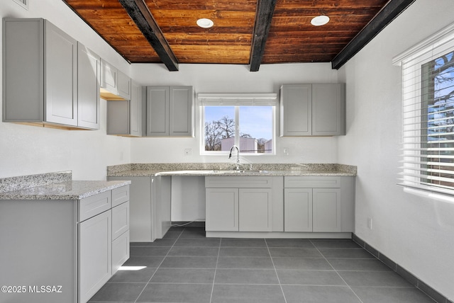 kitchen featuring gray cabinets, dark tile patterned flooring, wooden ceiling, and light stone countertops