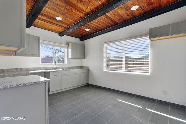 kitchen featuring wooden ceiling, tile patterned floors, beam ceiling, a sink, and recessed lighting