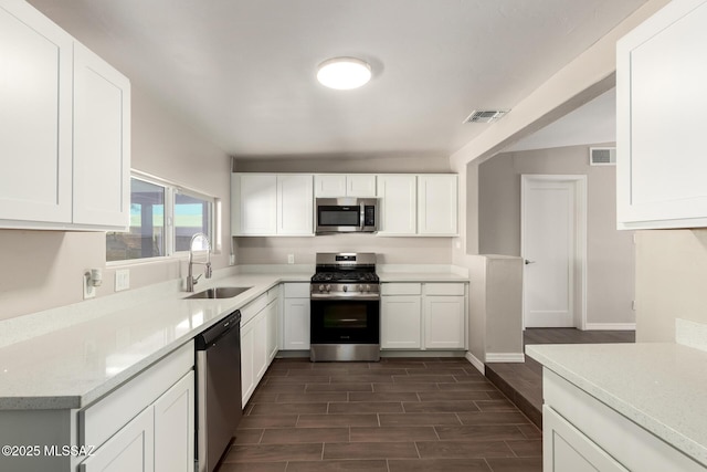 kitchen featuring visible vents, stainless steel appliances, a sink, and light countertops