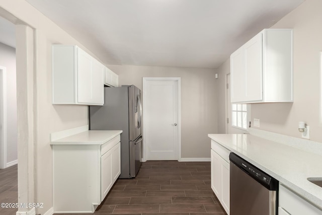 kitchen with white cabinetry, wood tiled floor, appliances with stainless steel finishes, and light countertops