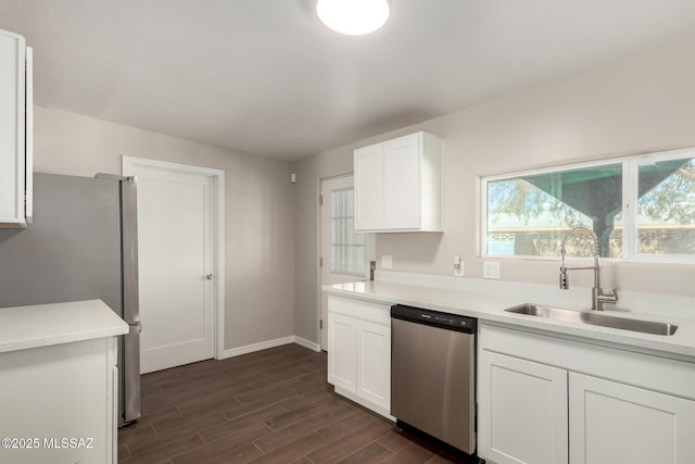 kitchen with wood tiled floor, stainless steel appliances, a sink, and light countertops