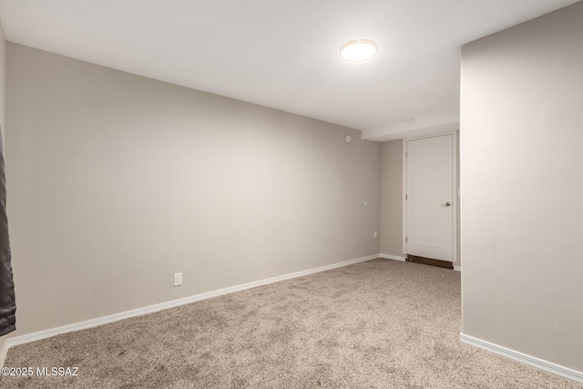 carpeted empty room featuring baseboards