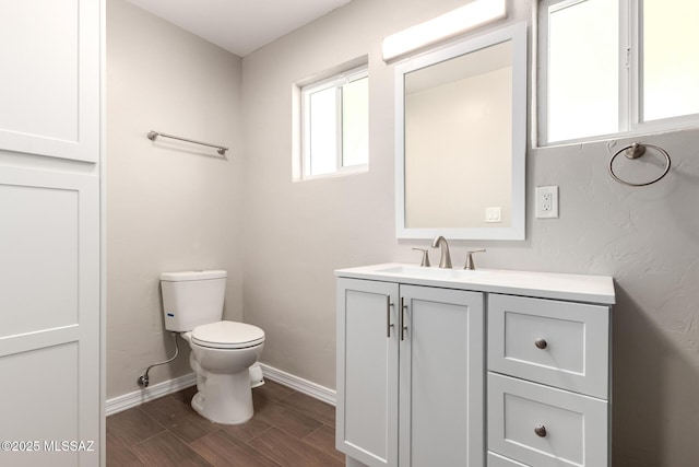 bathroom featuring wood tiled floor, vanity, toilet, and baseboards