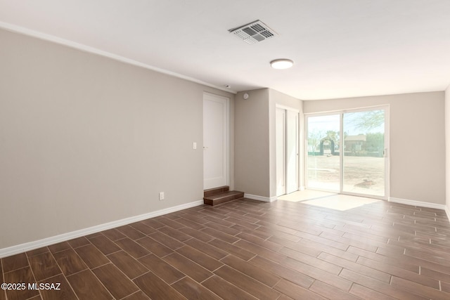 unfurnished room with dark wood-style floors, visible vents, and baseboards