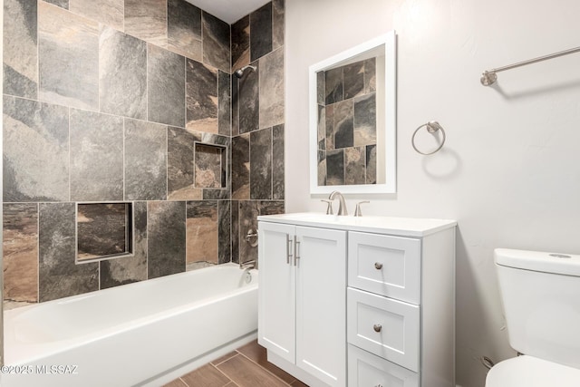 bathroom featuring toilet, tub / shower combination, wood finished floors, and vanity