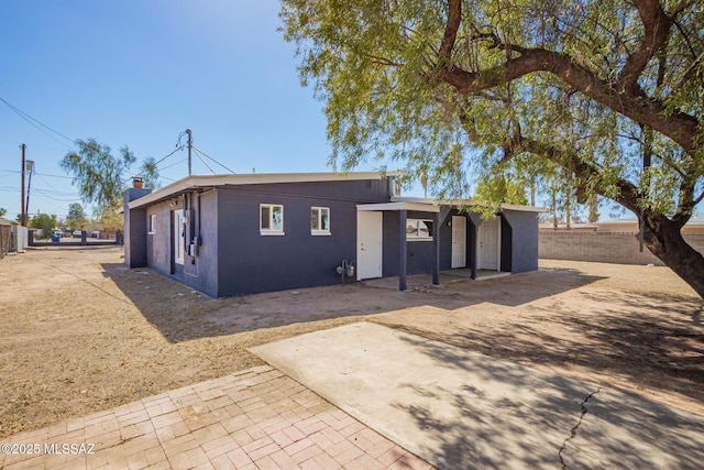 view of front of home featuring fence and a patio