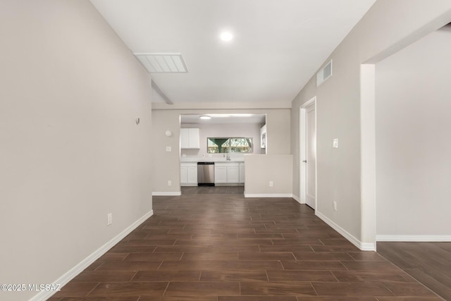 unfurnished living room featuring wood finish floors, visible vents, and baseboards