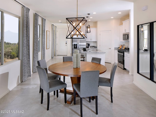 dining area with recessed lighting, a mountain view, a notable chandelier, and light tile patterned flooring