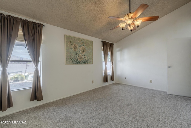 empty room featuring a textured ceiling, vaulted ceiling, carpet, and a ceiling fan