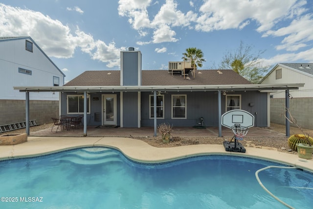 back of house featuring a patio, a chimney, fence, and an outdoor pool