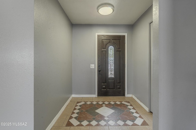 foyer with baseboards and light tile patterned floors