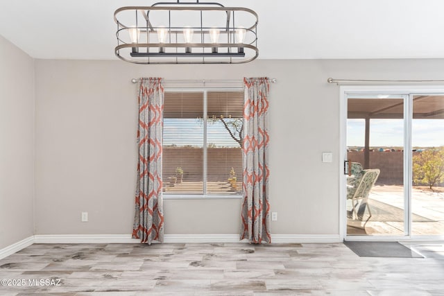 unfurnished dining area featuring baseboards and wood finished floors