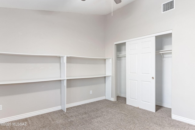 unfurnished bedroom with a ceiling fan, carpet, visible vents, baseboards, and a closet