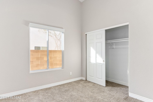 unfurnished bedroom featuring a closet, carpet floors, and baseboards