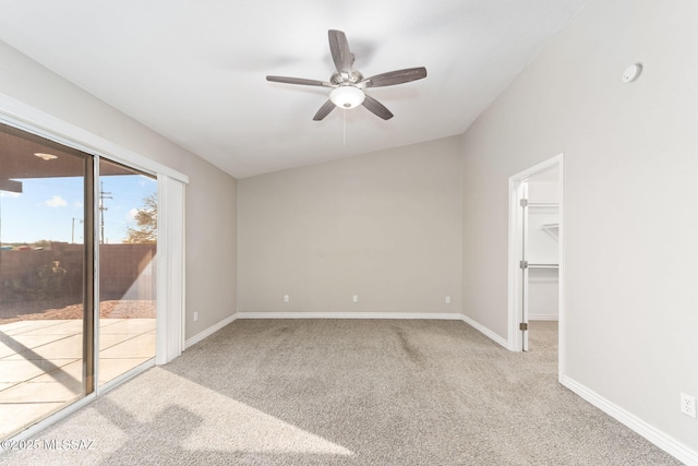 unfurnished bedroom featuring carpet, baseboards, ceiling fan, a walk in closet, and access to outside