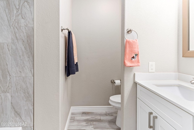 full bath featuring vanity, toilet, a shower, and baseboards