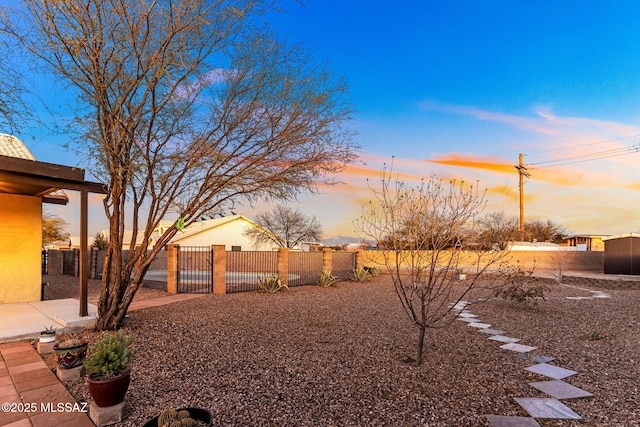 yard at dusk featuring fence