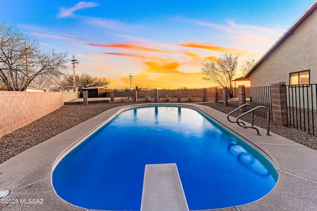 view of pool featuring a diving board, a fenced in pool, and a fenced backyard