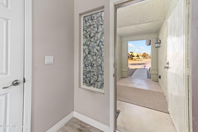 entryway featuring baseboards and wood finished floors