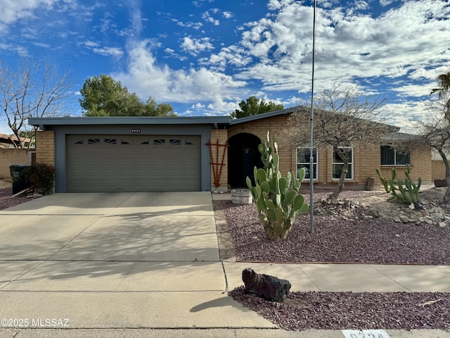 single story home featuring a garage, concrete driveway, and brick siding