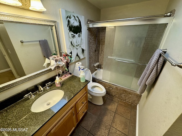 full bath with toilet, shower / bath combination with glass door, and vanity