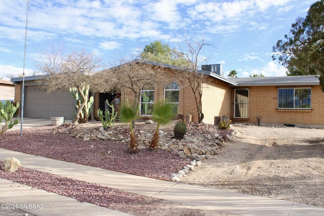 single story home with brick siding, driveway, and an attached garage