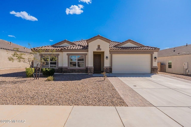 mediterranean / spanish-style house with concrete driveway, a garage, stone siding, and stucco siding