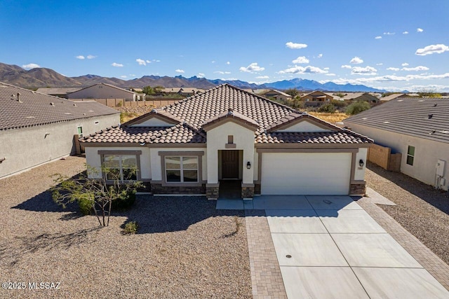 view of front facade featuring stucco siding, stone siding, a mountain view, concrete driveway, and a garage