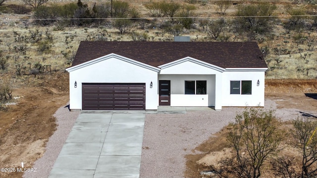 view of front of home with driveway, an attached garage, and stucco siding