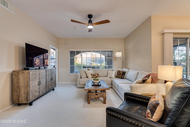 carpeted living area featuring a ceiling fan, visible vents, and baseboards