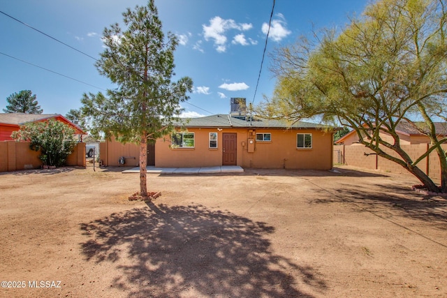 rear view of property featuring a patio area and fence