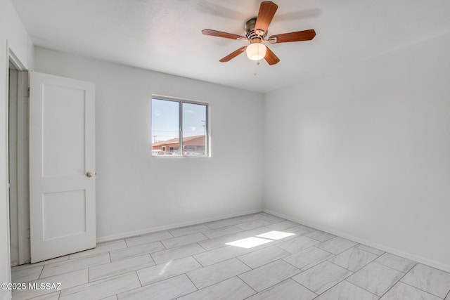 empty room with baseboards and a ceiling fan