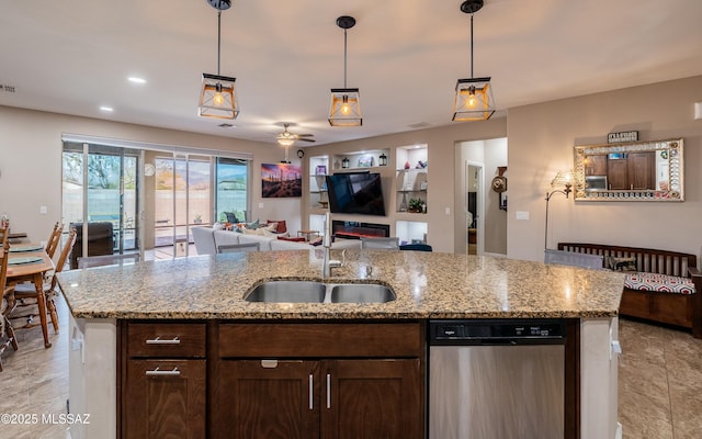 kitchen with pendant lighting, open floor plan, a sink, and dishwasher