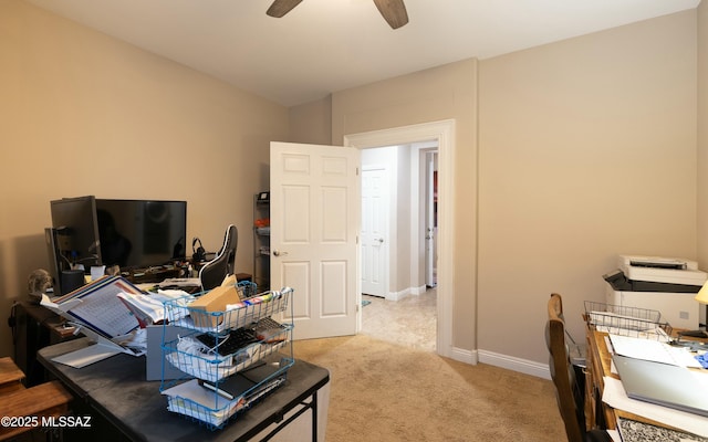 home office with light carpet, a ceiling fan, and baseboards