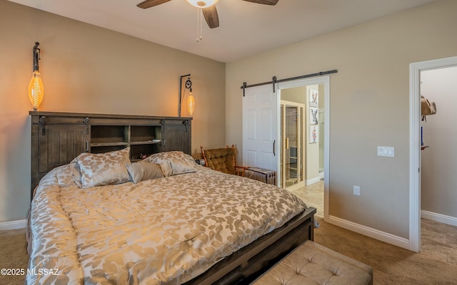 carpeted bedroom with a barn door, baseboards, and ceiling fan