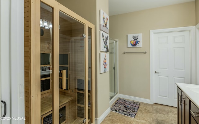 bathroom with a sauna, a shower stall, vanity, and baseboards