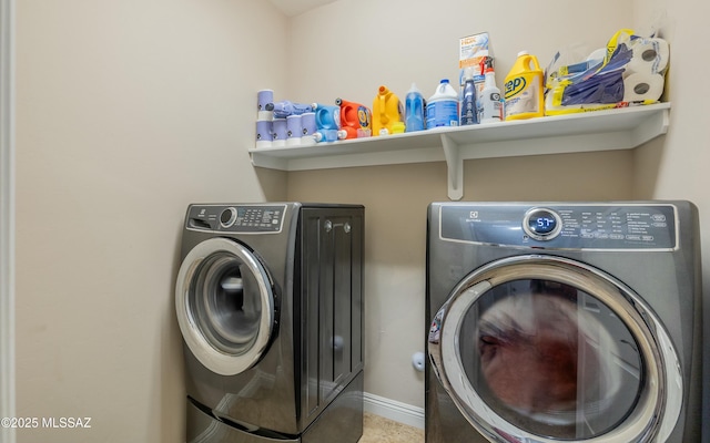 laundry area with laundry area, baseboards, and washing machine and clothes dryer